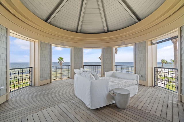 sunroom with lofted ceiling with beams and a water view