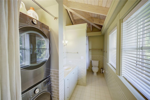 bathroom with tile patterned floors, stacked washer / dryer, toilet, and wood ceiling