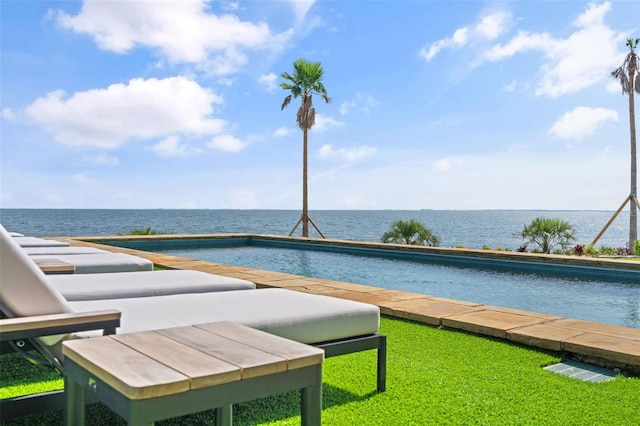 view of swimming pool featuring a water view and a lawn