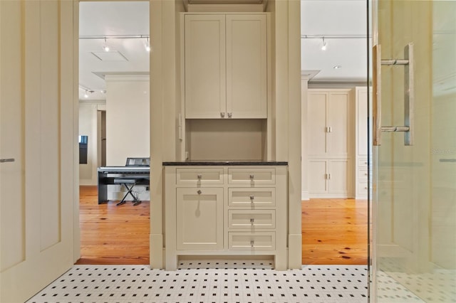 interior space featuring track lighting, light wood-type flooring, and ornamental molding