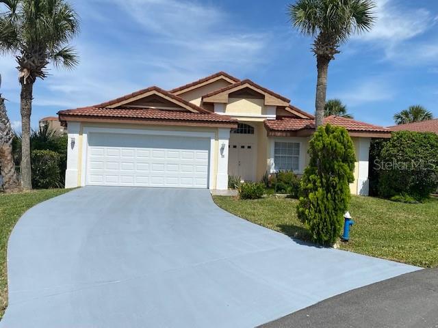 mediterranean / spanish house featuring a front yard and a garage