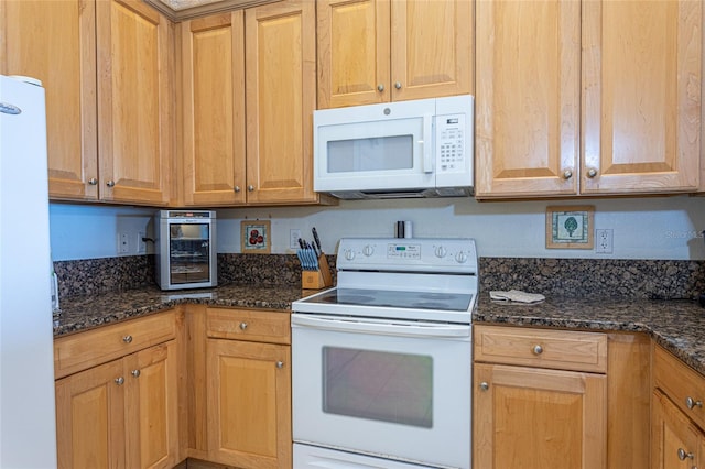 kitchen with dark stone countertops and white appliances