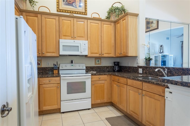 kitchen with white appliances, sink, ceiling fan, dark stone counters, and light tile patterned flooring