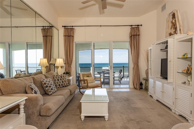 living area with light carpet, visible vents, and ceiling fan