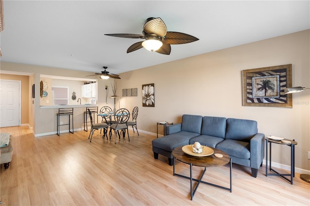 living room with ceiling fan and light wood-type flooring