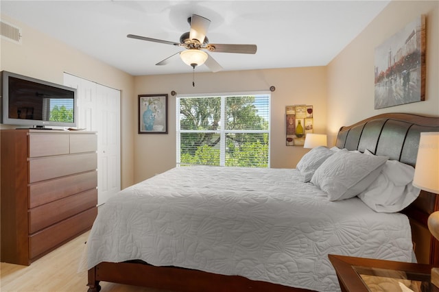 bedroom featuring light hardwood / wood-style flooring, ceiling fan, and a closet