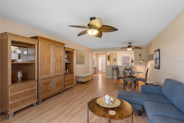 living room with light hardwood / wood-style flooring and ceiling fan