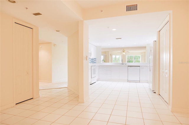 tiled spare room featuring ceiling fan and sink