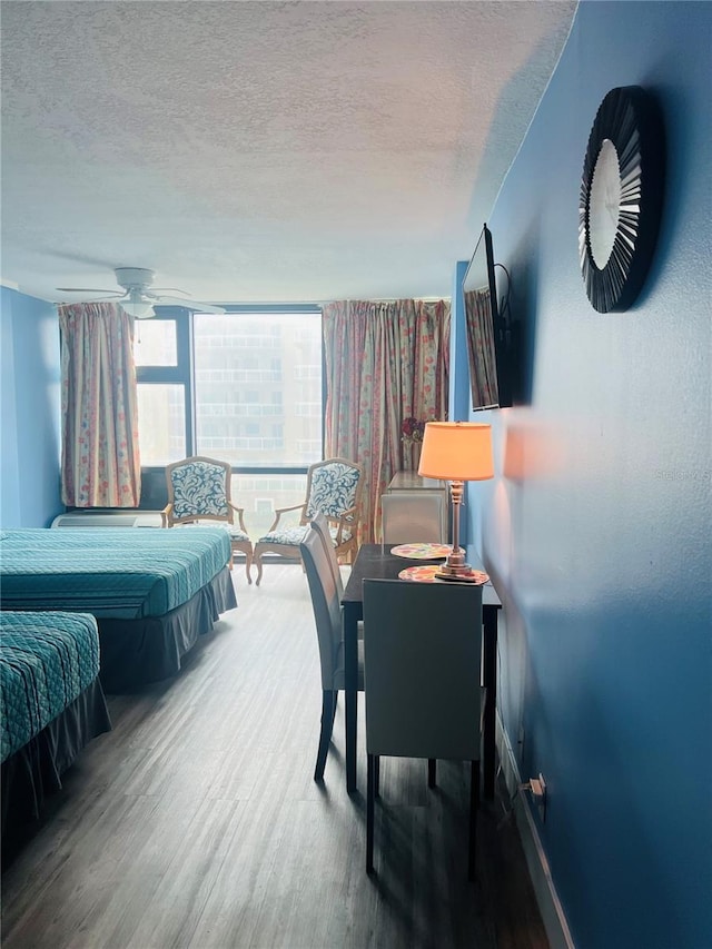 bedroom with a wall of windows, a textured ceiling, and dark hardwood / wood-style flooring