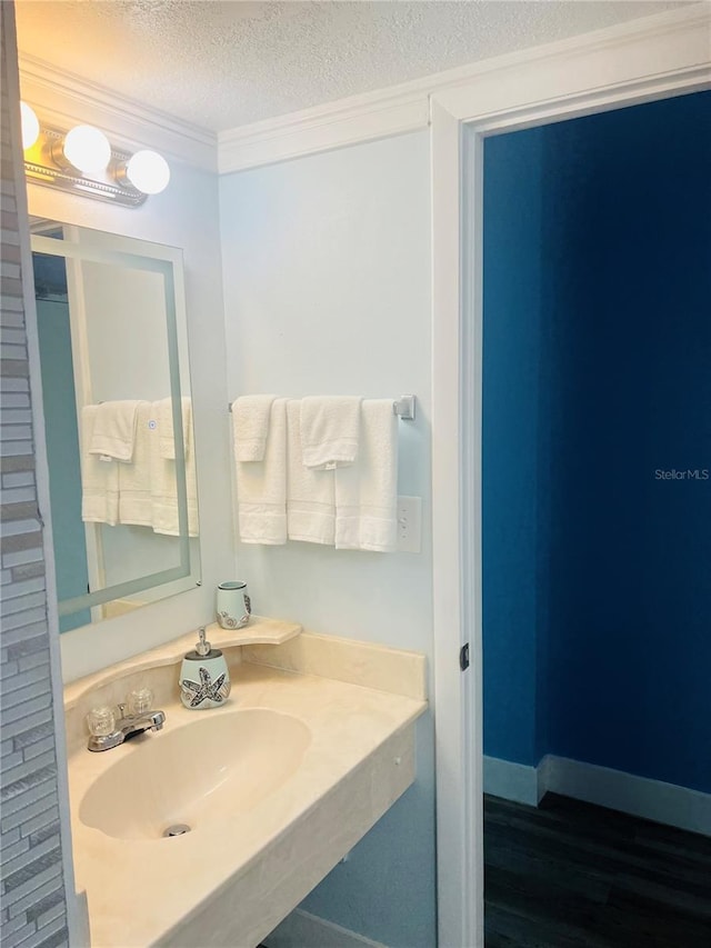 bathroom featuring a textured ceiling, sink, and hardwood / wood-style flooring