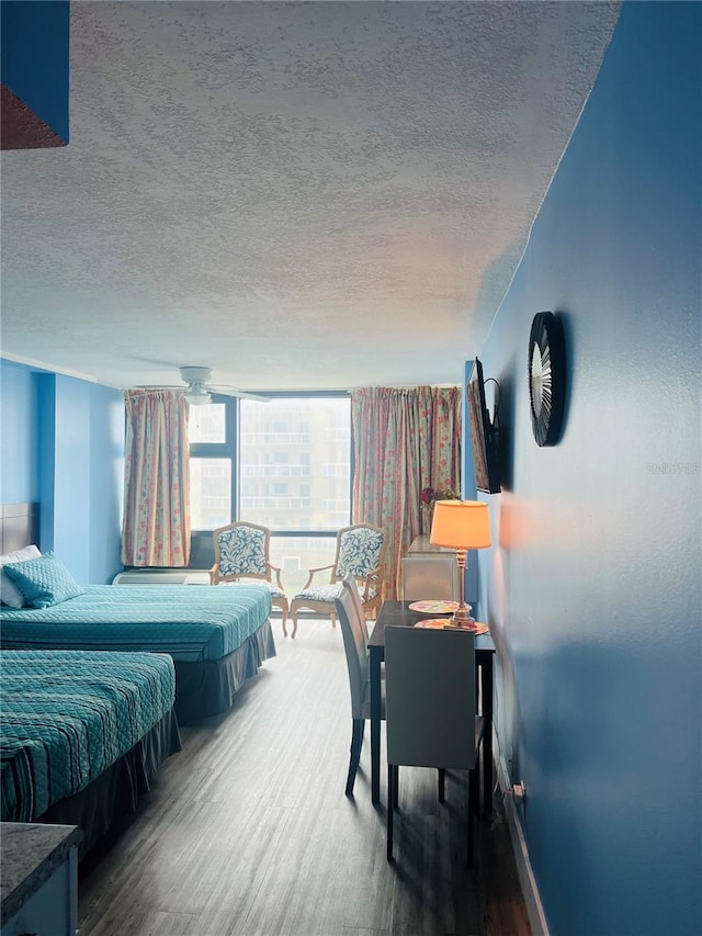 bedroom with a textured ceiling and dark hardwood / wood-style flooring