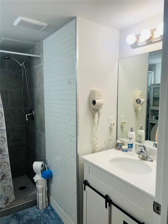 bathroom featuring walk in shower and vanity