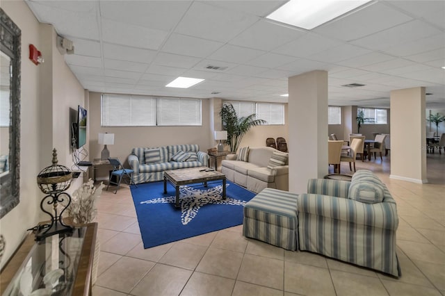 living room with light tile patterned floors and a drop ceiling