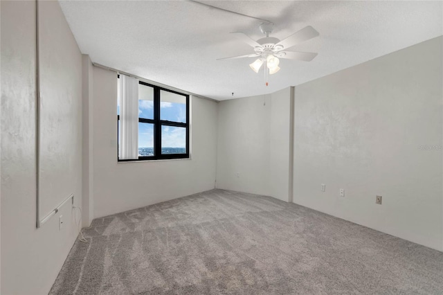 carpeted empty room with a textured ceiling and ceiling fan