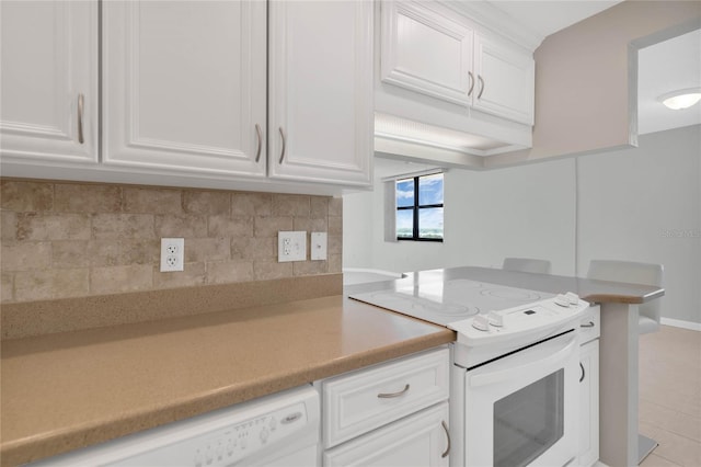 kitchen with light tile patterned floors, white appliances, tasteful backsplash, and white cabinetry