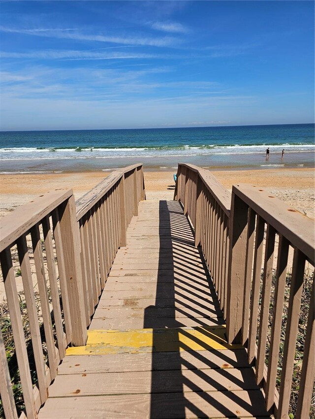 surrounding community with a water view and a view of the beach