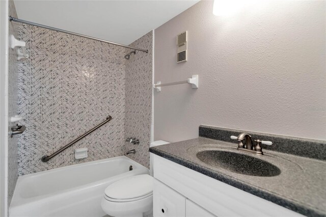 full bathroom featuring vanity, tiled shower / bath combo, and toilet