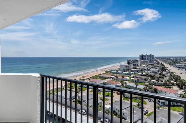 balcony with a water view and a view of the beach