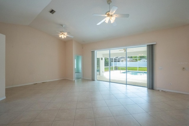 spare room featuring ceiling fan, vaulted ceiling, and light tile patterned flooring