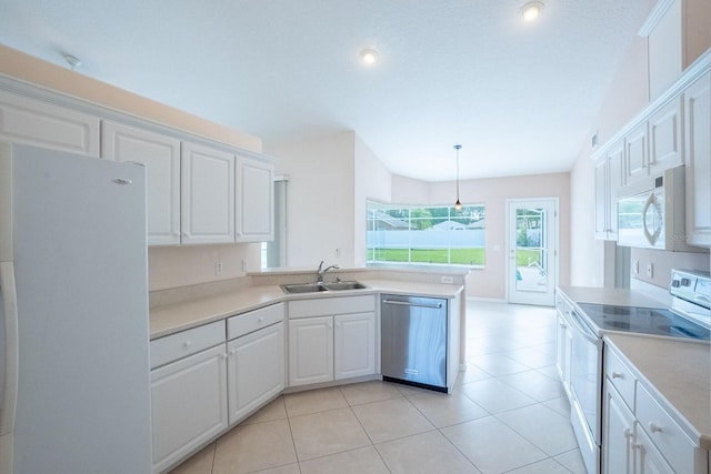 kitchen featuring decorative light fixtures, white appliances, sink, white cabinetry, and light tile patterned flooring