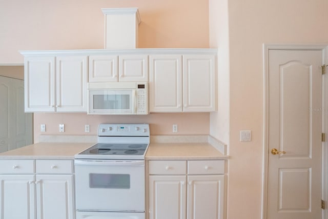 kitchen featuring white appliances and white cabinetry