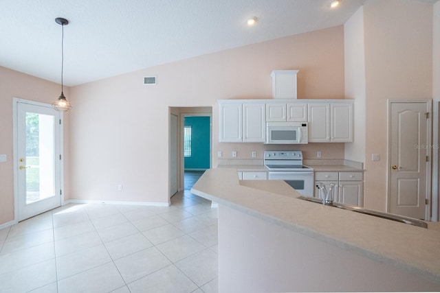 kitchen with white appliances, pendant lighting, light tile patterned floors, lofted ceiling, and white cabinets