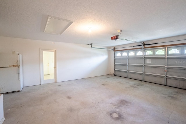 garage featuring white fridge and a garage door opener