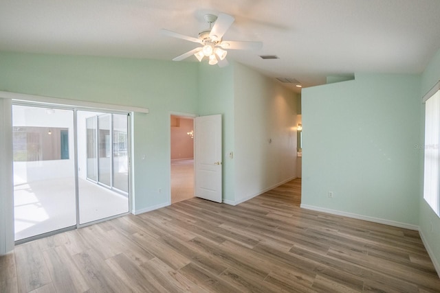 unfurnished room featuring light wood-type flooring, vaulted ceiling, a healthy amount of sunlight, and ceiling fan