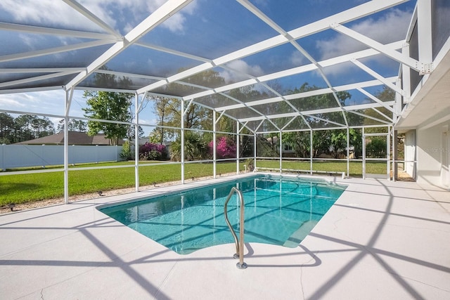 view of pool with glass enclosure, a yard, and a patio