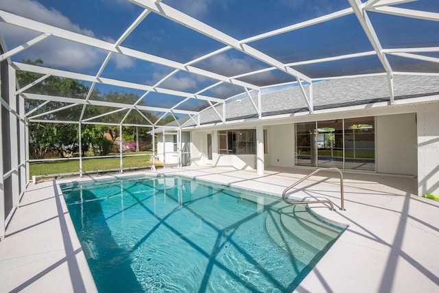 view of pool featuring glass enclosure and a patio