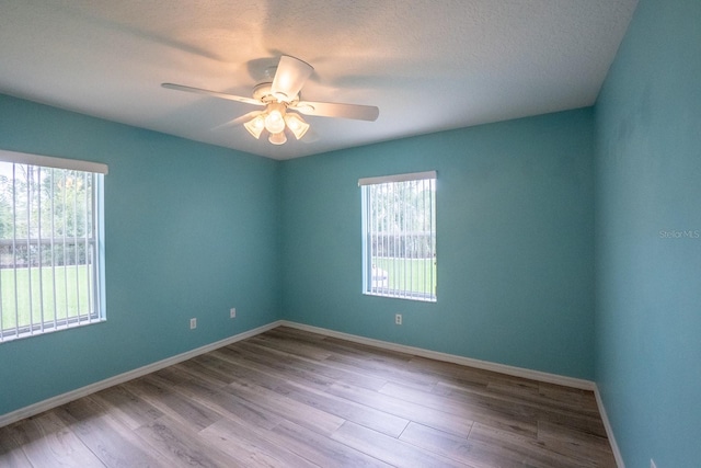 spare room featuring a textured ceiling, light hardwood / wood-style flooring, and ceiling fan