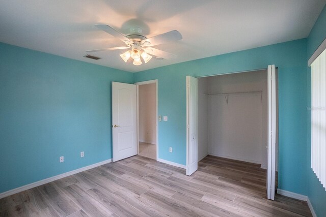 unfurnished bedroom with light hardwood / wood-style flooring, ceiling fan, and a closet