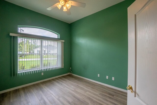 empty room with ceiling fan and light hardwood / wood-style flooring