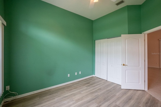 unfurnished bedroom featuring light wood-type flooring, ceiling fan, and a closet