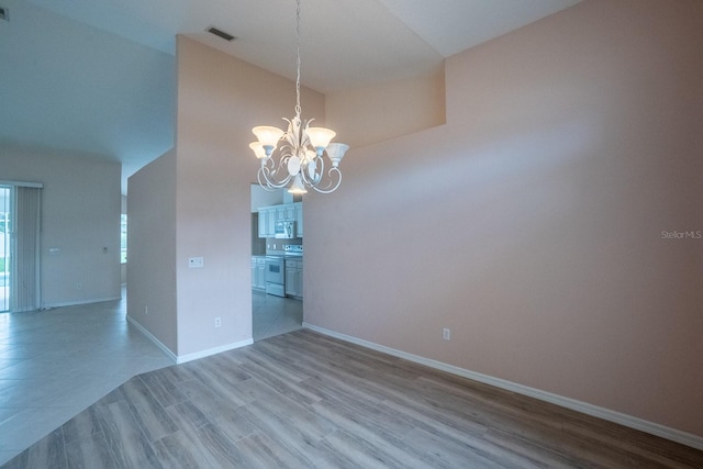 empty room featuring an inviting chandelier and wood-type flooring