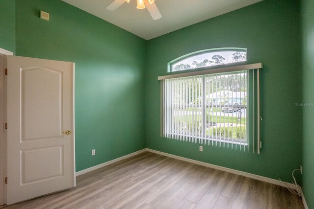 spare room featuring a wealth of natural light, ceiling fan, and light hardwood / wood-style floors