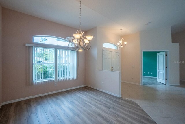 unfurnished room featuring light hardwood / wood-style floors and a notable chandelier