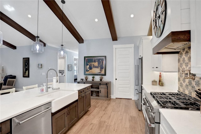 kitchen featuring white cabinets, decorative light fixtures, sink, beam ceiling, and high quality appliances