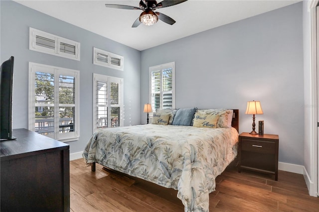 bedroom featuring ceiling fan, multiple windows, and wood-type flooring