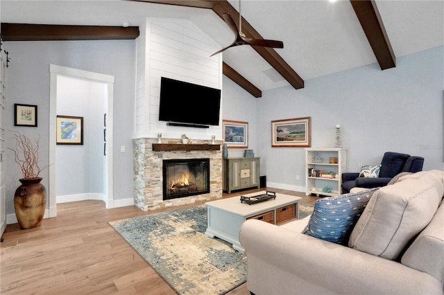 living room featuring a fireplace, ceiling fan, high vaulted ceiling, light hardwood / wood-style flooring, and beam ceiling