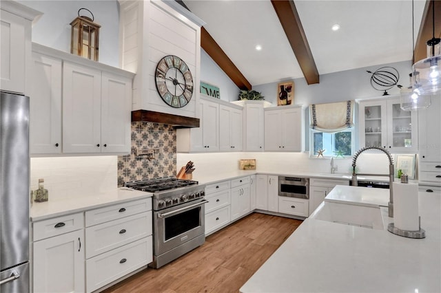 kitchen with backsplash, pendant lighting, lofted ceiling with beams, stainless steel appliances, and white cabinets