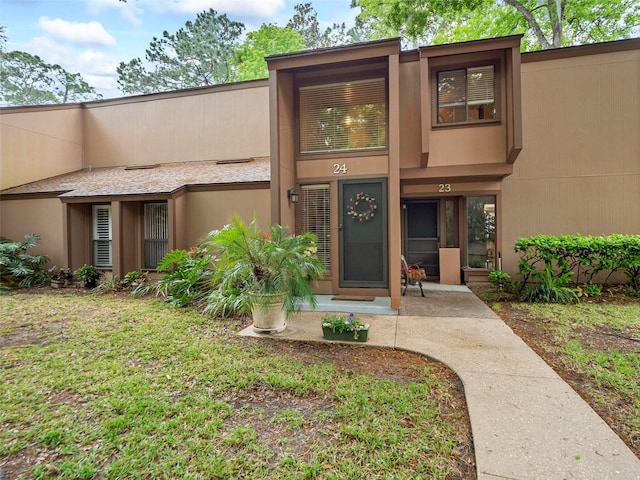24 Mid Pines Cir Unit 24, Palm Coast, FL 32137 - property entrance with stucco siding and a yard