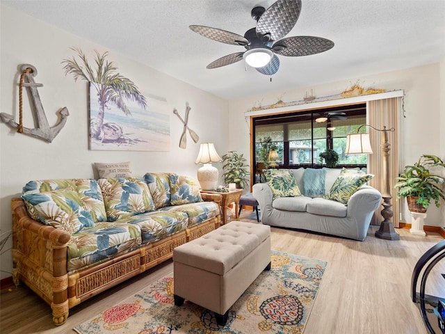 living room with a textured ceiling, light hardwood / wood-style floors, and ceiling fan