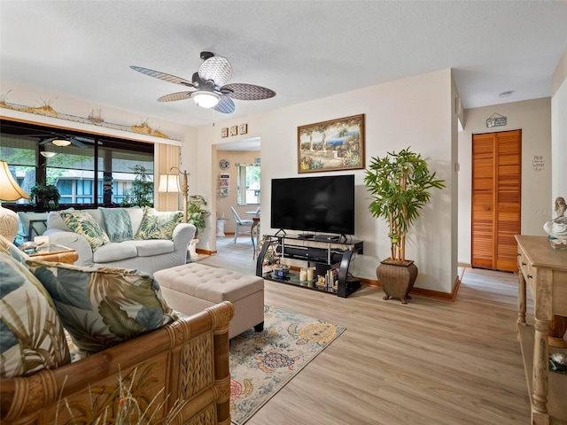 living room featuring ceiling fan and light hardwood / wood-style flooring