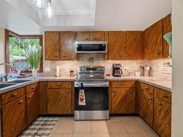 kitchen with backsplash, light tile floors, appliances with stainless steel finishes, and sink