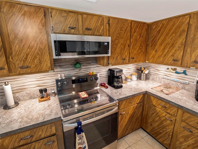 kitchen featuring tasteful backsplash, light tile flooring, and stainless steel appliances