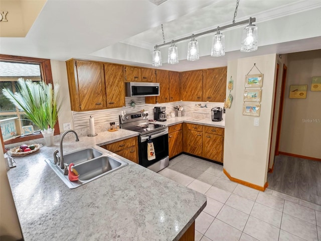 kitchen featuring pendant lighting, stainless steel appliances, crown molding, backsplash, and sink