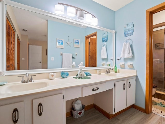 bathroom with oversized vanity, hardwood / wood-style floors, toilet, and double sink