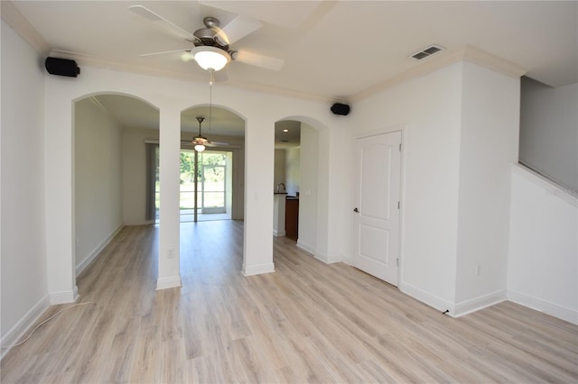 empty room with ornamental molding, ceiling fan, and light wood-type flooring