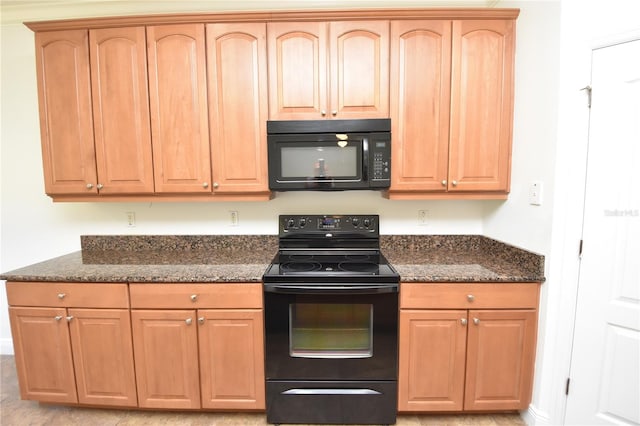 kitchen featuring dark stone countertops and black appliances